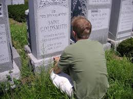individual sitting in front of gravestone
